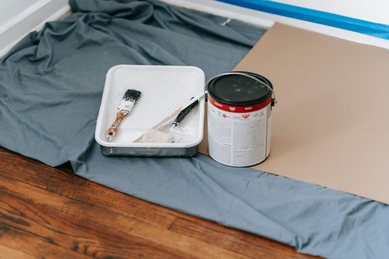 A collection of painting tools and materials prepared for a home renovation project indoors.